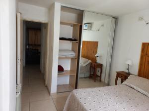 1 dormitorio con 1 cama y 1 habitación con armario en Departamento Eutico en Villa Carlos Paz