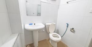 a white bathroom with a toilet and a sink at Dealings Freedom Rest in Gampola