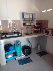 uma cozinha com um lavatório e uma bancada em Bonda Guesthouse III em Paka
