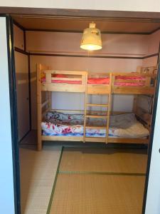 um beliche com três beliches num quarto em 山下ビル307 em Kurosakimachi