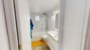 a white bathroom with a sink and a toilet at Apartamentos Eldorado in Lloret de Mar +37 photos