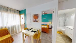 a living room with a table and a bathroom at Apartamentos Eldorado in Lloret de Mar