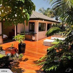 a wooden deck in front of a house at Palm Garden Beach House in Papamoa