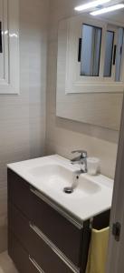 a bathroom with a white sink and a mirror at Barcelona, Apartamento de 2 habitaciones. in Hospitalet de Llobregat
