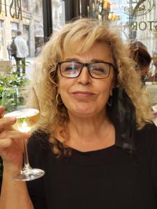 a woman with glasses holding a glass of wine at Beatrice Hospitality in Neve Zohar