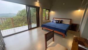 a bedroom with a blue bed and a balcony at Antharyamin in Trivandrum