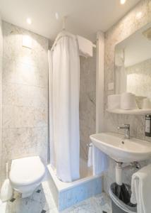 ein weißes Bad mit einem WC und einem Waschbecken in der Unterkunft The Guesthouse by The Hey Hotel in Interlaken