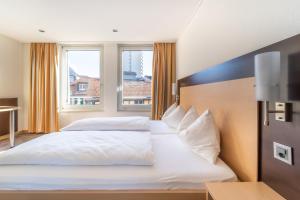 ein Hotelzimmer mit 2 Betten und einem Fenster in der Unterkunft The Guesthouse by The Hey Hotel in Interlaken