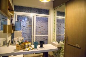 una piccola cucina con un lavandino e una finestra di One Heart Inn a Tainan