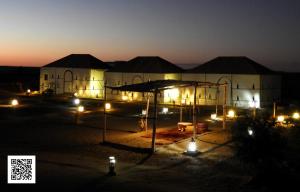 un edificio con luces delante de él por la noche en Room in Guest room - Luxury Desert Camp - Merzouga, en Tisserdmine