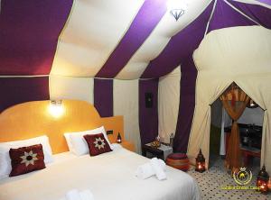 1 dormitorio con 1 cama y 1 tienda de campaña en Room in Guest room - Luxury Desert Camp - Merzouga, en Tisserdmine