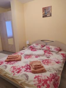 Una cama con flores rosas y toallas. en Raia, en Stara Zagora