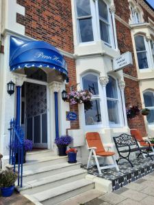 a house with a blue umbrella and a bench on the doorstep at Penn House Hotel in Weymouth