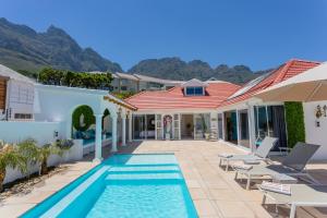 a villa with a swimming pool and a house at La Casita Villa in Cape Town