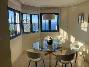 jadalnia ze szklanym stołem i krzesłami w obiekcie Infinity Apartment w Almuñécar