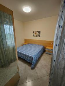 a bedroom with a bed with a blue comforter at Appartamenti RoccaForte MONO BLU Trapani in Milo