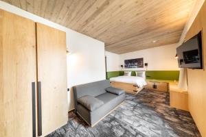 um quarto de hotel com uma cama e um sofá em De BrauHotel em Bascharage