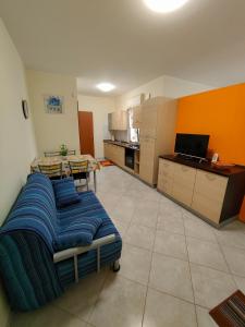 a living room with a bed and a kitchen at Appartamenti RoccaForte MONO BLU Trapani in Milo