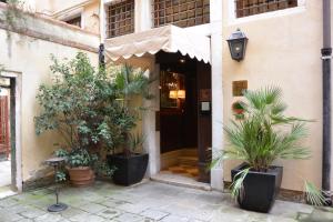 uma entrada para um edifício com vasos de plantas em Duodo Palace em Veneza