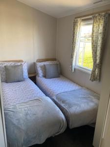 North SeatonにあるSandy bay mariners riseの窓のある小さな部屋にベッドが2つある