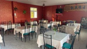 a dining room with tables and chairs and a tv at Hua Xiang Motel - Fengshan in Kaohsiung