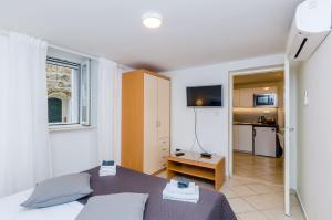 a bedroom with a bed and a kitchen in a room at Apartment Domix in Dubrovnik
