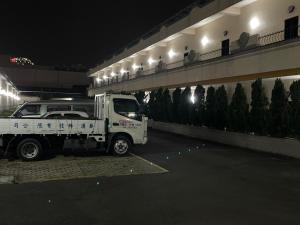 Un camión blanco estacionado al lado de un edificio por la noche en Hua Xiang Motel - Fengshan en Kaohsiung