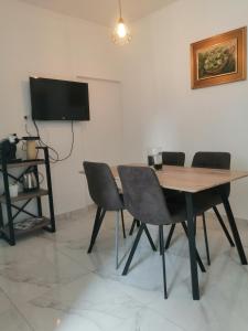 a dining room with a wooden table and chairs at Apartman Marita in Kaštela