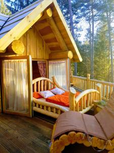 Cabaña de madera con 2 camas en una terraza en Glamping Lake Bloke, en Nova Vas