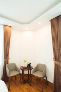 une chambre d'hôtel avec deux chaises et une table dans l'établissement Realux Hotel, à Sầm Sơn