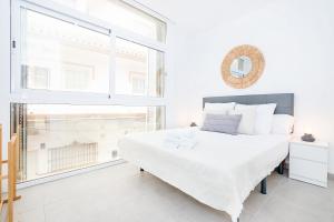 a white bedroom with a large bed and a window at Cala de Mijas Summer Vibes in Mijas Costa +8 photos