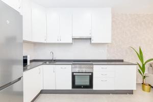 a white kitchen with white cabinets and a sink at Cala de Mijas Summer Vibes in Mijas Costa