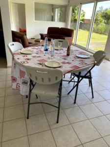 tavolo da pranzo con sedie e tovaglia; di Maison accueillante, quartier verdoyant a Sainte-Marie