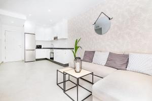 a white living room with a couch and a table at Cala de Mijas Summer Vibes in Mijas Costa