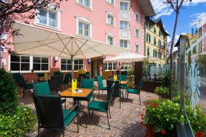 a patio with tables and chairs and a building at Cityhotel Goldener Adler B&B in Chiusa