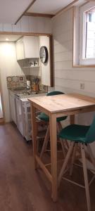 cocina con mesa de madera y sillas verdes en Gite o vert, en Malleville-sur-le-Bec