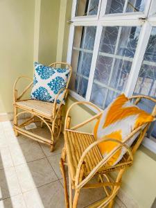 a porch with two chairs and a window at Elegant and cozy studio apartment in Nairobi Ruaka in Ruaka
