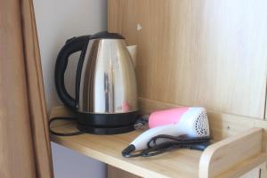 a tea kettle and a phone on a shelf at Huy Đạt Hotel in Phan Thiet +19 photos