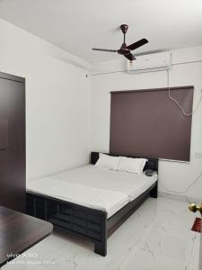 a bed in a room with a ceiling fan at SHRISTI HEIGHT in Kolkata
