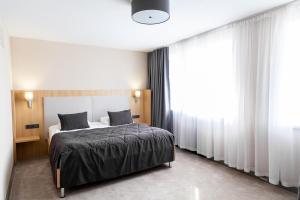 a bedroom with a bed and a large window at Hotel Сomplex Irtysh in Pavlodar
