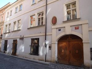a white building with two wooden doors on a street at U Cervene zidle - Red Chair Hotel in Prague