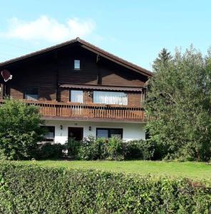 a wooden house with a balcony on top of it at Fewo Oehlenschlaeger Nr 53 Eg in Arrach
