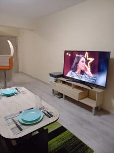 Dima's place في كازانلوك: غرفة معيشة مع طاولة وتلفزيون بشاشة مسطحة