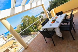 Una mesa en un balcón con vista al mar. en Apartamentos Carlton VyB, en Denia