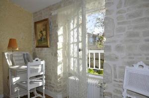 a room with a window and a desk with a computer at Le Puits Sainte Claire in Courçon