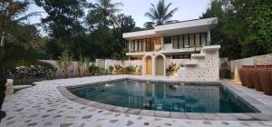 une maison avec une piscine en face de celle-ci dans l'établissement Tiu Oasis Lombok, à Kuta Lombok