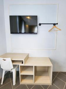 a desk and a chair with a television on a wall at Mac Hotel by Sky Hive in George Town