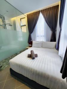 a bedroom with a large white bed with a window at Mac Hotel by Sky Hive in George Town