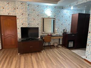 ein Wohnzimmer mit einem TV und einer Wand in der Unterkunft Hua Xiang Motel - Fengshan in Kaohsiung