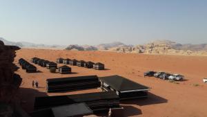 a group of buildings in a desert with mountains at Salem Camp in Wadi Rum